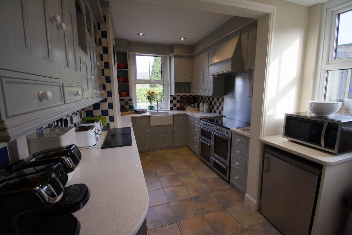 A modern kitchen with a central island, built-in appliances, and a window providing natural light.