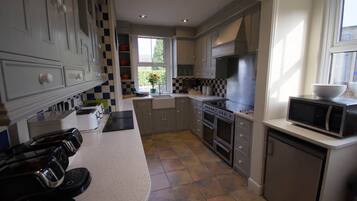 A modern kitchen with a central island, built-in appliances, and a window providing natural light.
