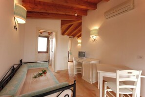A bedroom with a bed, a desk, and a chair. There is a television on the desk. - Relaxing Residence Baia dei Mirti Studio M3-3 Persons-unit 2 (Aglientu)