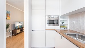 Eine moderne Küche mit weißen Schränken, einem eingebauten Backofen und einer Holz Arbeitsplatte.