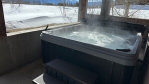 Un bain à remous avec vue sur un paysage enneigé et des montagnes.