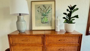 A wooden chest of drawers with a lamp and a framed painting on top. - Raven's View - Walk to town, beach, restaurants (Inverness)