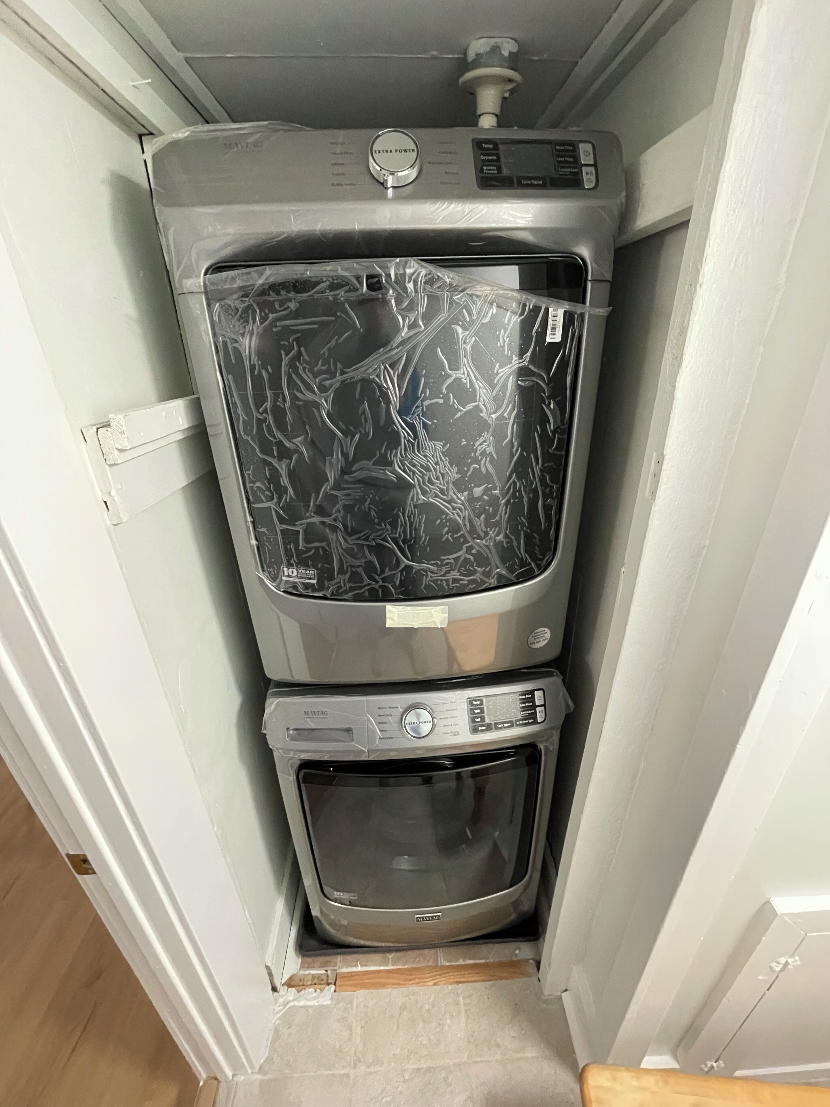A compact kitchen with a microwave and oven, a small window, and a door with a handle.