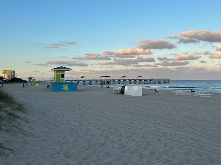 Una playa cerca, sillas reclinables de playa, sombrillas