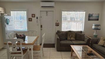 A living room with a dining area, a sofa, and a coffee table.