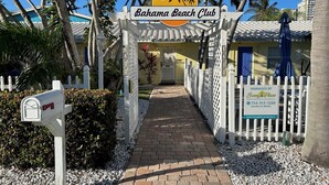 A pathway leading to a building with a sign reading "Bahama Beach Club". - Bahama Beach Club Pompano (Pompano Beach)