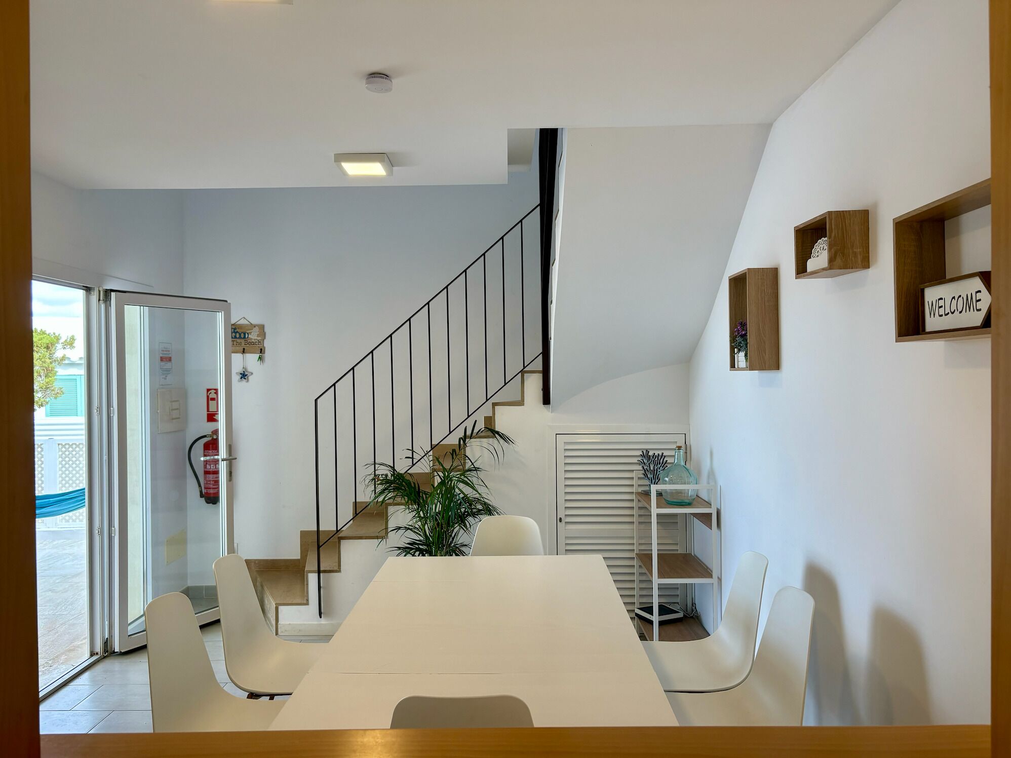A modern interior with a staircase, a dining area, and a reception desk.
