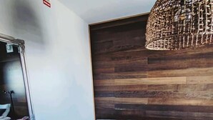Uma sala de estar moderna com um sofá azul escuro, uma mesinha redonda e um espelho grande.