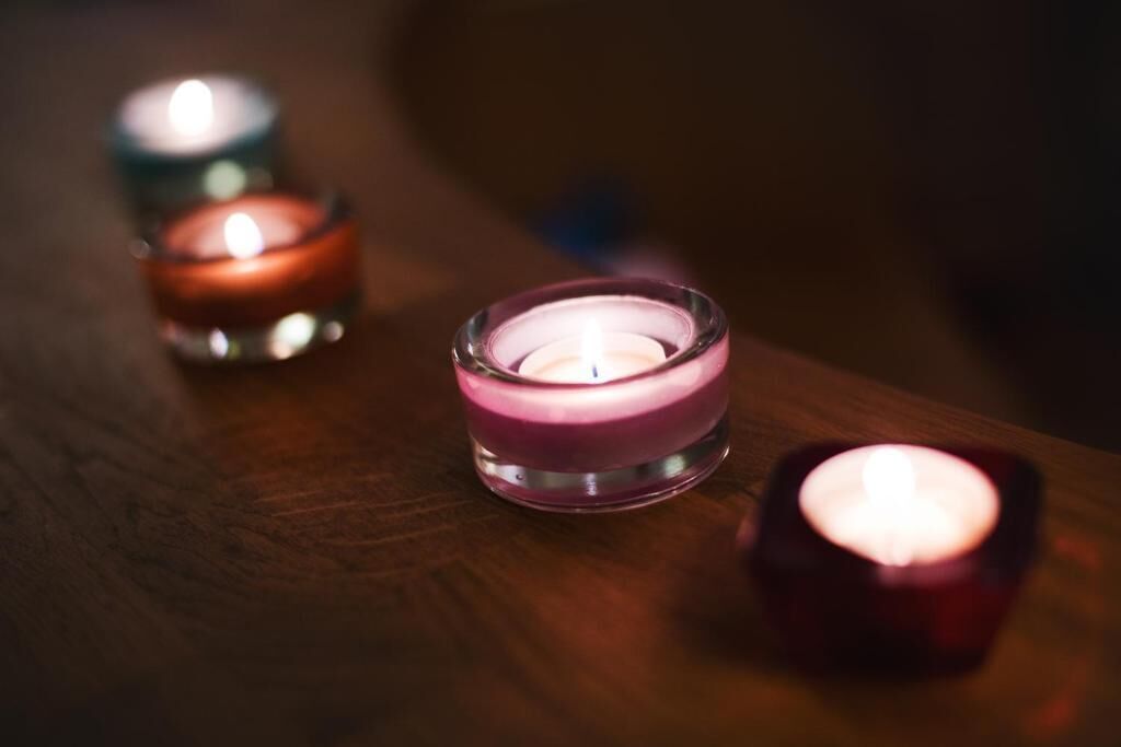 Three candles on a wooden surface.