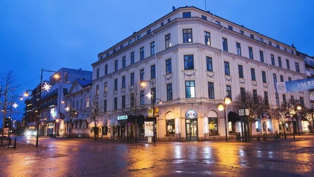 Um edifício histórico com estilo arquitetônico clássico, apresentando uma entrada central com uma grande porta em arco e várias janelas.