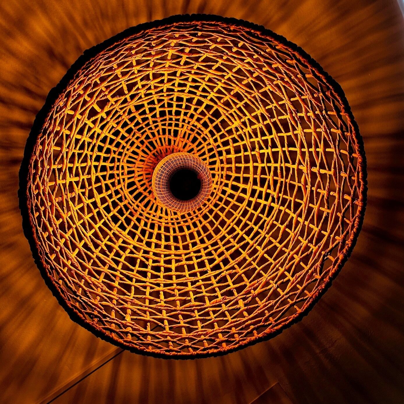 A circular woven structure with a central dark opening.