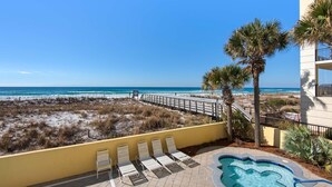 A pool area with lounge chairs and a view of the beach. - Pelican Isle 117 (Fort Walton Beach)