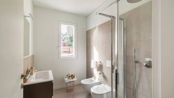 Une salle de bain moderne équipée d’une douche, de toilettes et d’un lavabo.