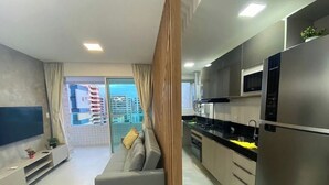 A modern apartment with a kitchen, living area, and balcony with a city view. - Edificio Promenade II - Apt 604 (Maceio)