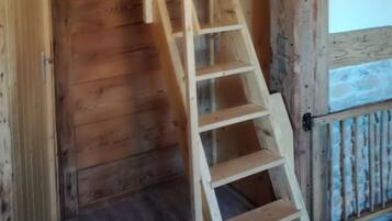A wooden staircase with a metal railing, leading to a higher floor.