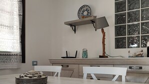 A kitchen with a large island, white chairs, a hanging lamp, and a decorative plate on the wall. - Charming 2-bedroom cottage with WiFi, AC in lovely Quartu Sant'Elena (Quartu Sant'Elena)