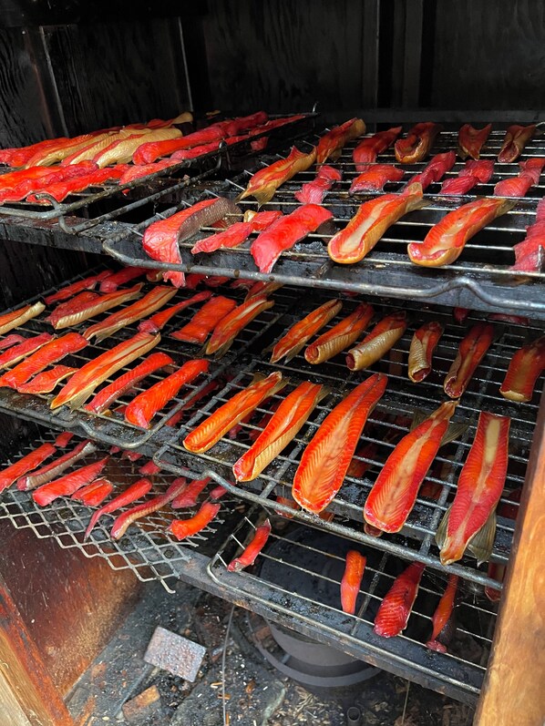 Un gril doté de plusieurs niveaux sur lesquels sont disposées des brochettes d’aliments variés.