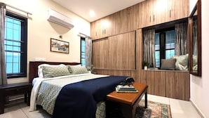 Un dormitorio con cama, mesita de noche, cómoda y ventana con cortinas.