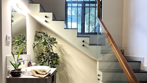 Un baño moderno con tocador de madera, un espejo grande y dos plantas en macetas.