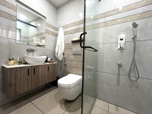 Een douche, handdoeken, zeep, toiletpapier