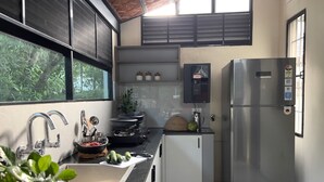 Una cocina moderna con electrodomésticos de acero inoxidable, un lavamanos y una ventana con vistas a zonas verdes.