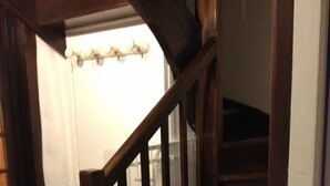 Una escalera de madera con barandilla de cristal que conduce a un piso superior.