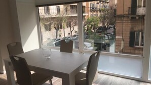 Una habitación moderna con un ventanal grande, una mesa de comedor y dos sillas.