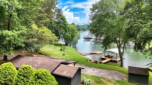 Une propriété située au bord du lac, dotée d’un quai, de pelouses et d’un petit abri de jardin.