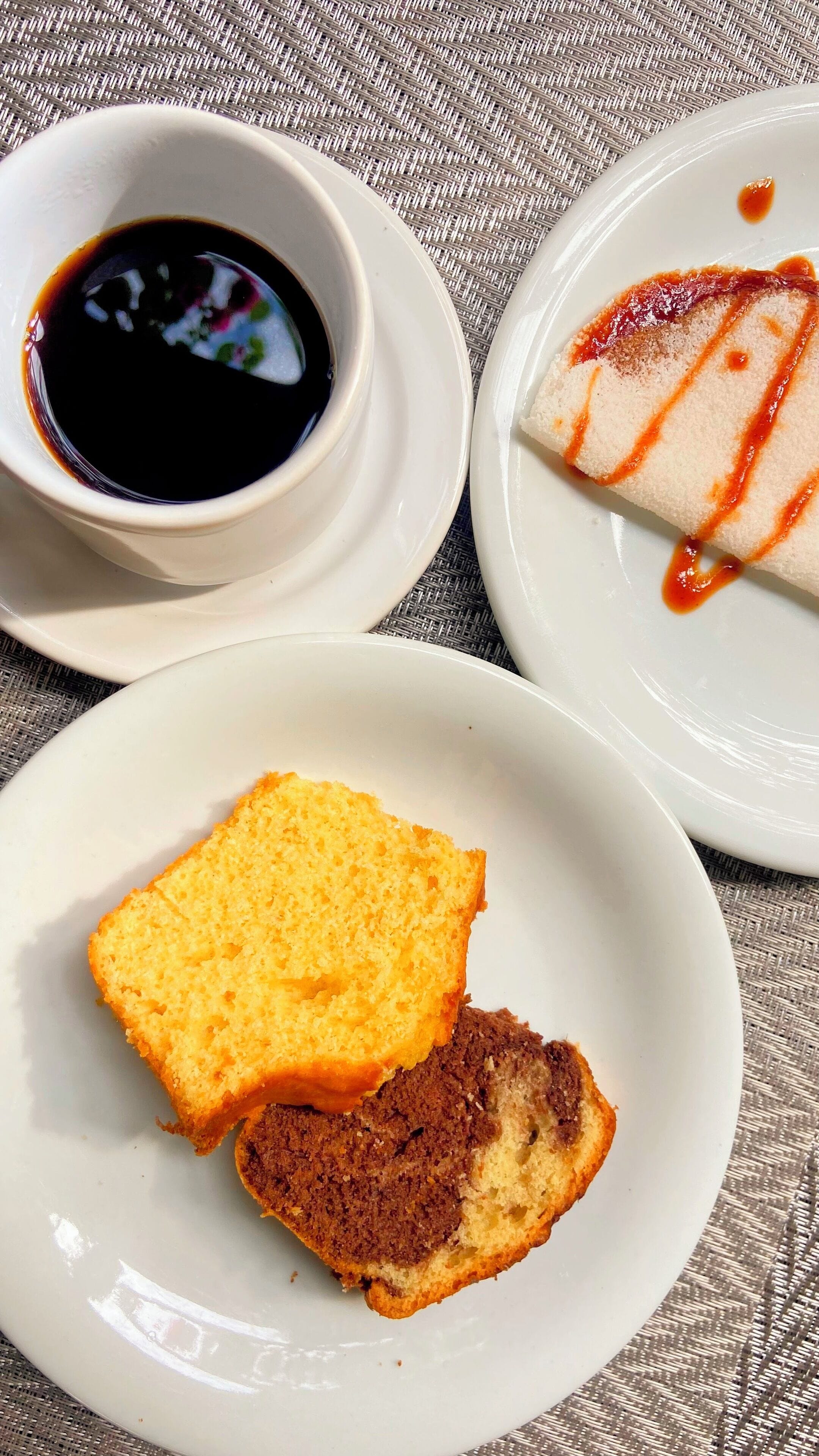 Three white plates with food items and a small bowl of sauce.