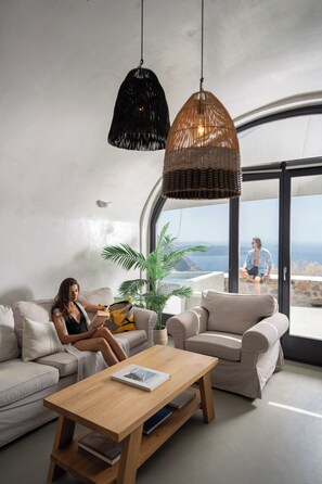 Una sala moderna con un sofá, una mesa de centro y vistas al océano.