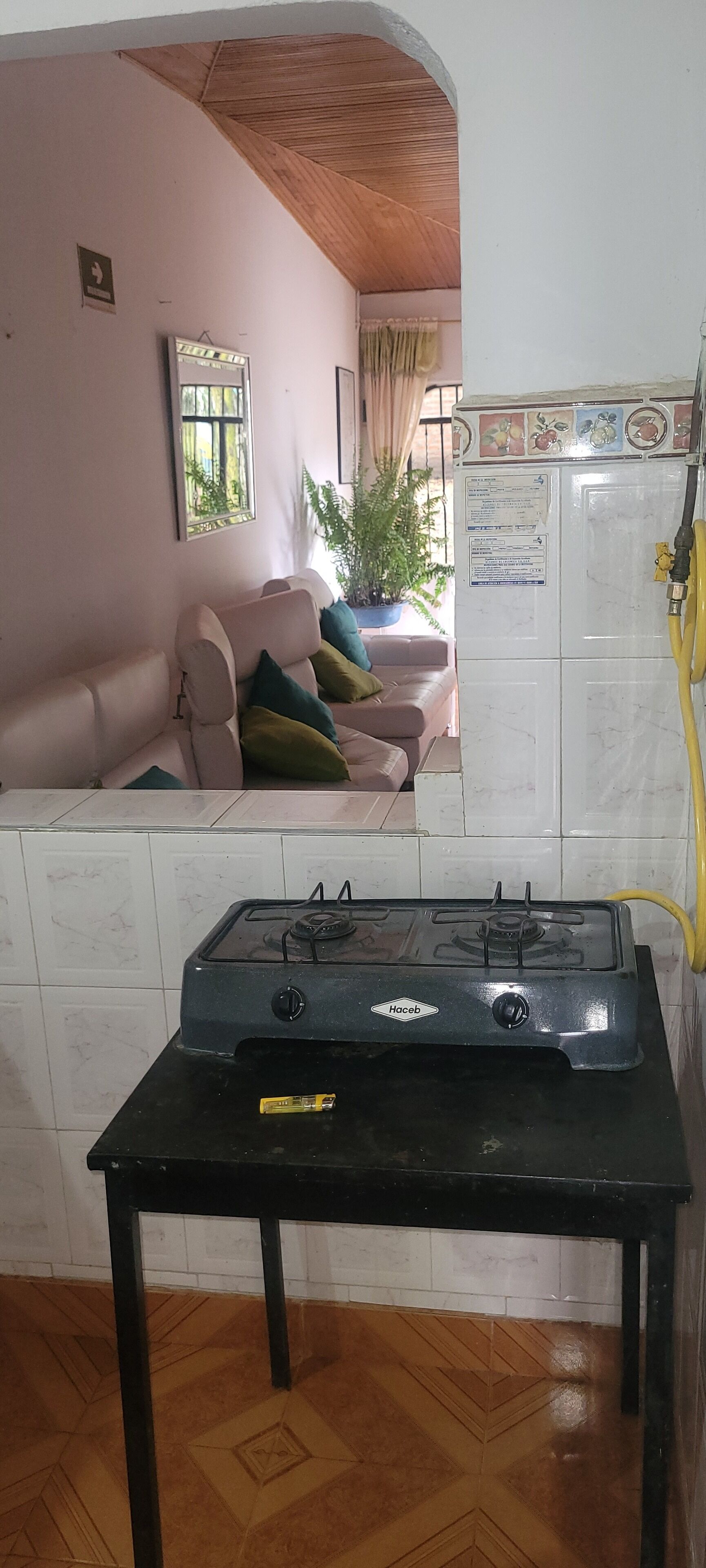 Una cocina con estufa a gas, refrigerador y una mesa de comedor.