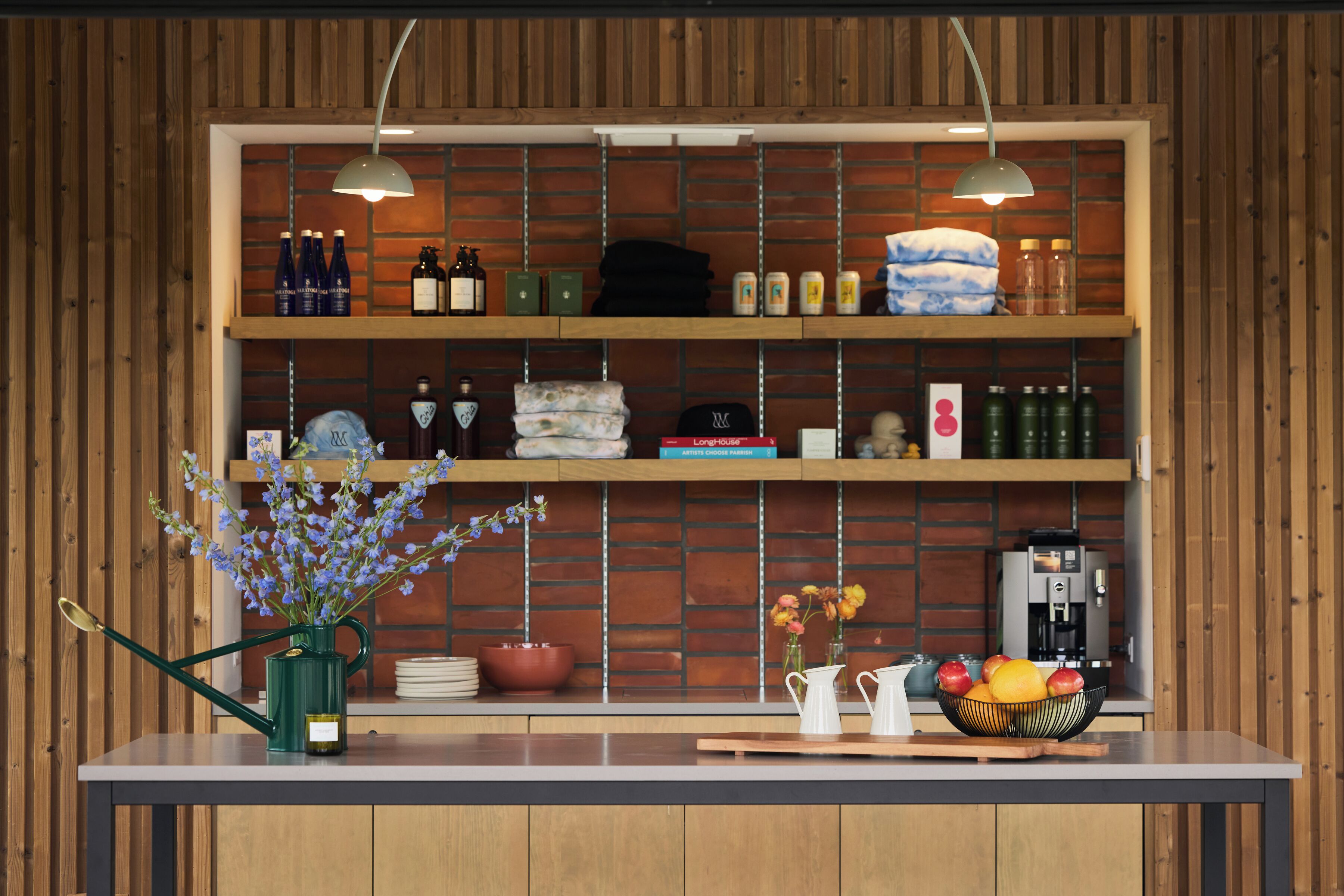 A kitchen with wooden cabinets, a coffee machine, and a fruit bowl on the counter.