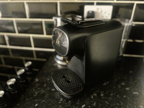 Una máquina de café con un panel de control sobre una encimera de cocina.