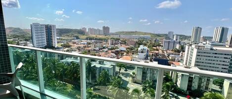 Un edifici alt amb vista a un paisatge urbà, incloent diversos edificis i un cos d'aigua a la distància.
