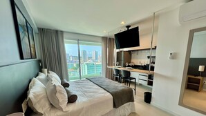 A modern hotel room with a large bed, a small kitchenette, and a city view. - RN STUDIO - APTO 905 (Maceió)