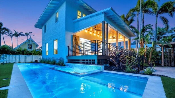 A modern house with a swimming pool, a covered patio, and a view of the surrounding landscape. - Playa Palma Private Pool Home 4 Minute Walk to Holmes Beach on AMI (Holmes Beach)