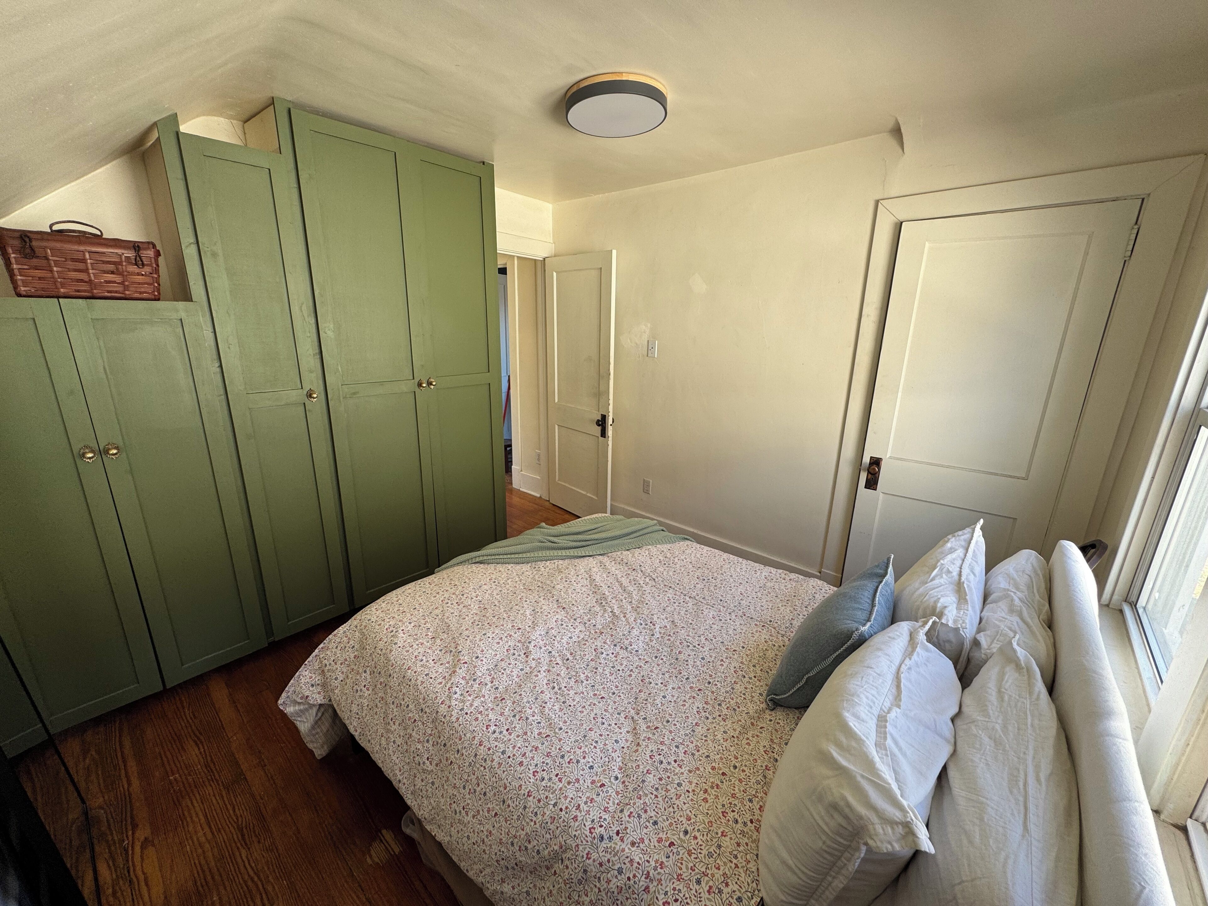 Une chambre à coucher avec un lit, une armoire et une porte.