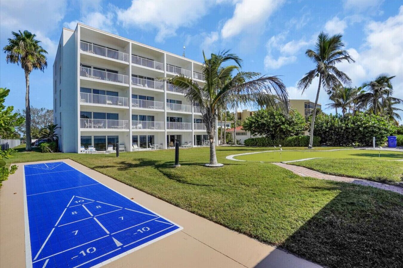 A multi-story hotel with a pool area, including a shuffleboard court.