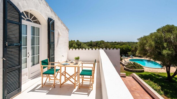 A terrace with a table and chairs, a pool, and a view of the landscape. - New! Casa Nova de Biniparrell (Biniparrell)