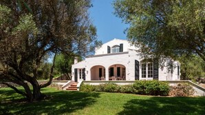 A white house with a stone facade, arched windows, and a front porch. - New! Casa Nova de Biniparrell (Biniparrell)