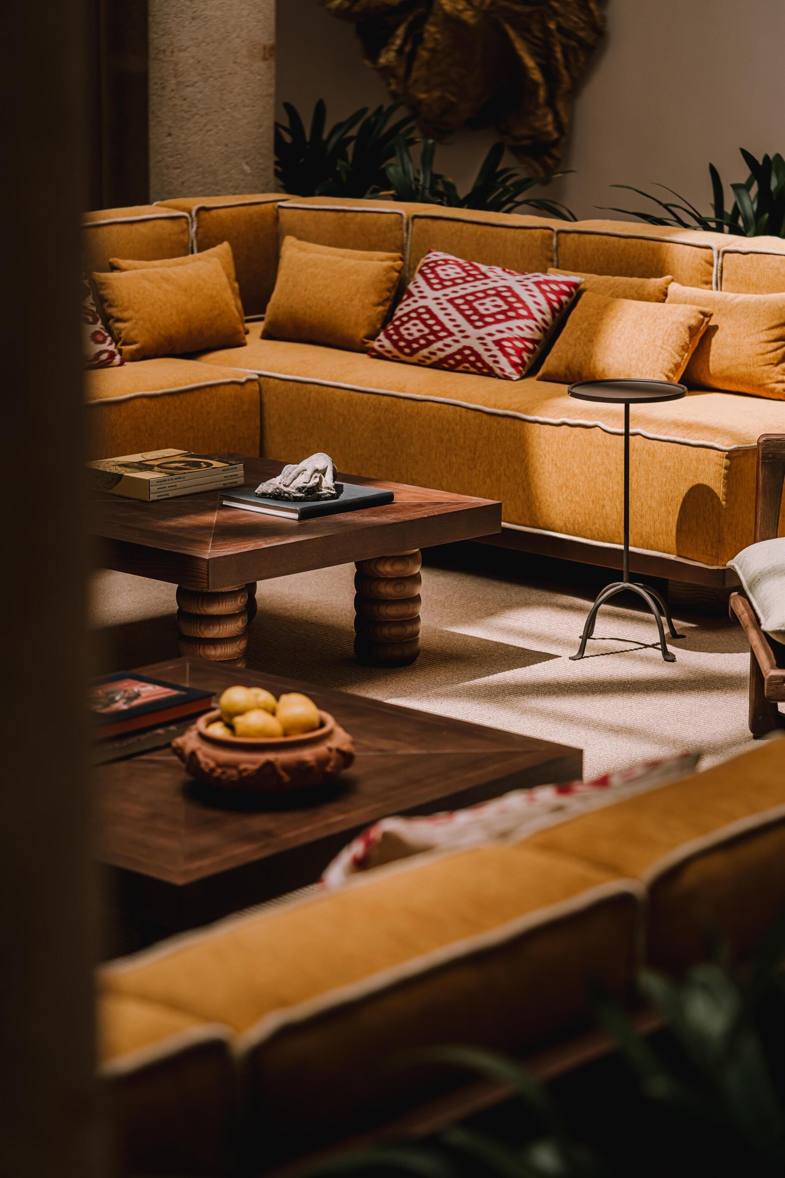 Una sala de estar acogedora con un sofá modular, una mesa de centro y una mesita auxiliar.