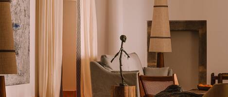Una sala acogedora con chimenea, un sofá, una mesa de centro y una lámpara.