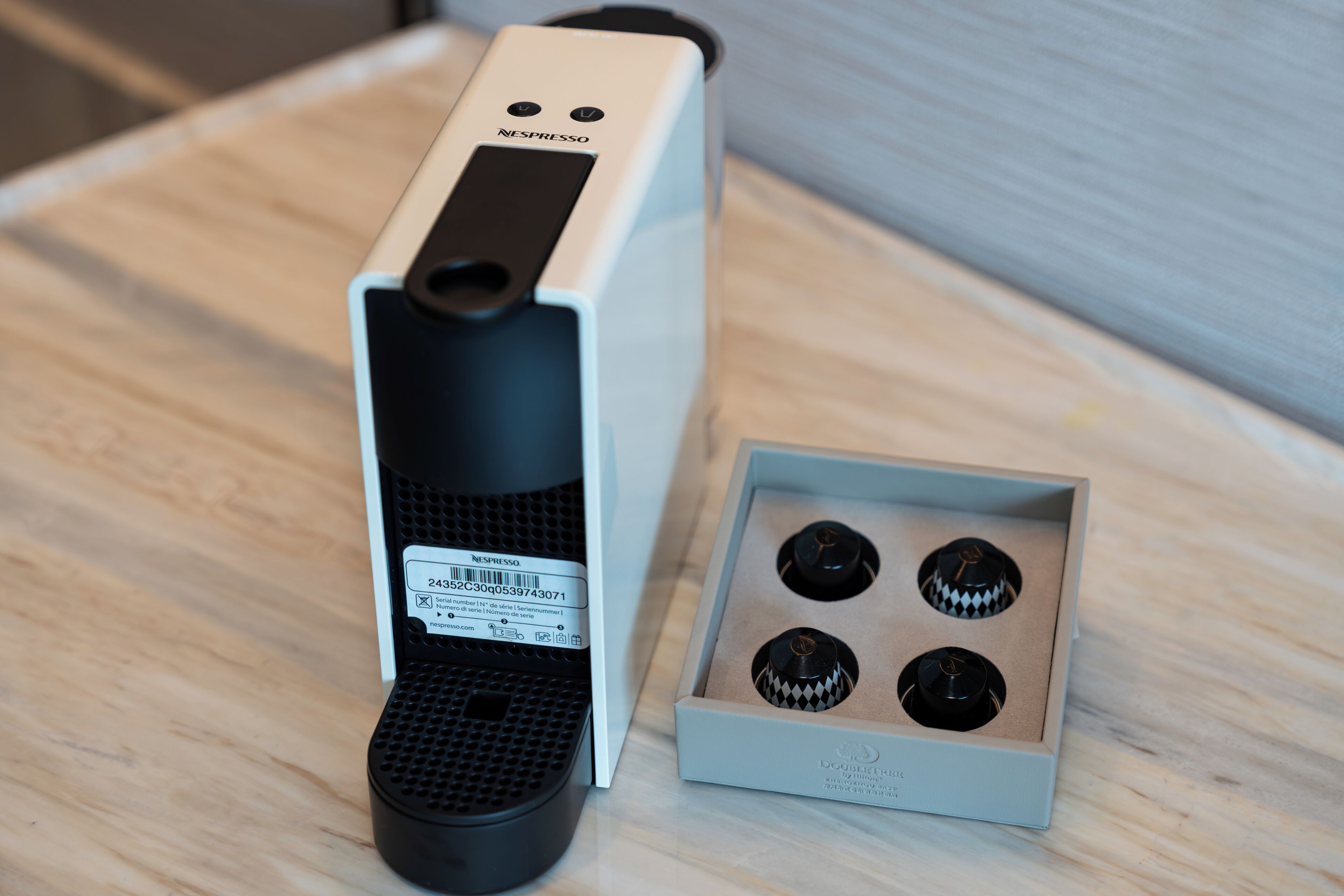 Eine Nespresso-Maschine mit Originalverpackung und vier Kapseln.