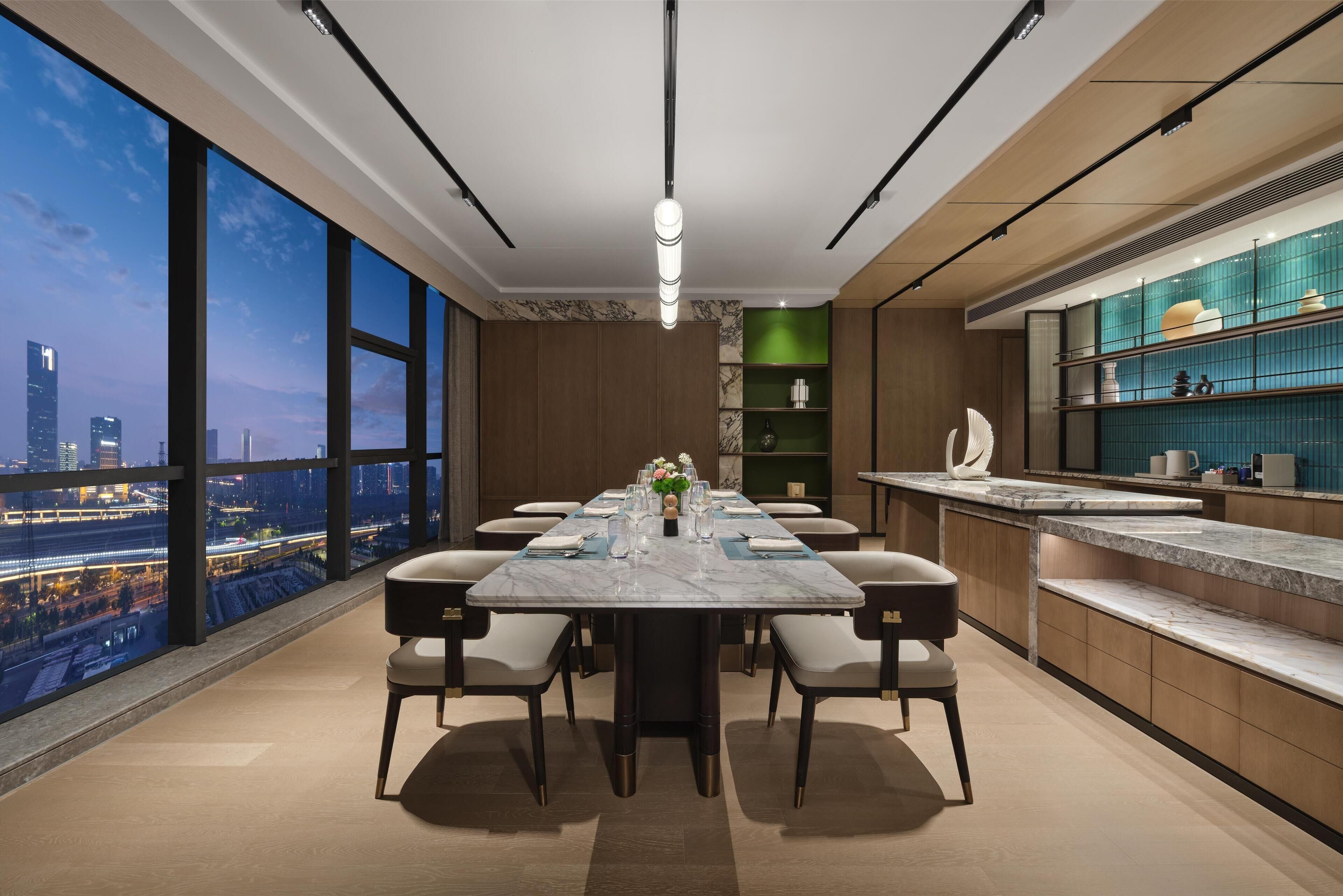 Un comedor moderno con una mesa grande, sillas y vistas a la ciudad.