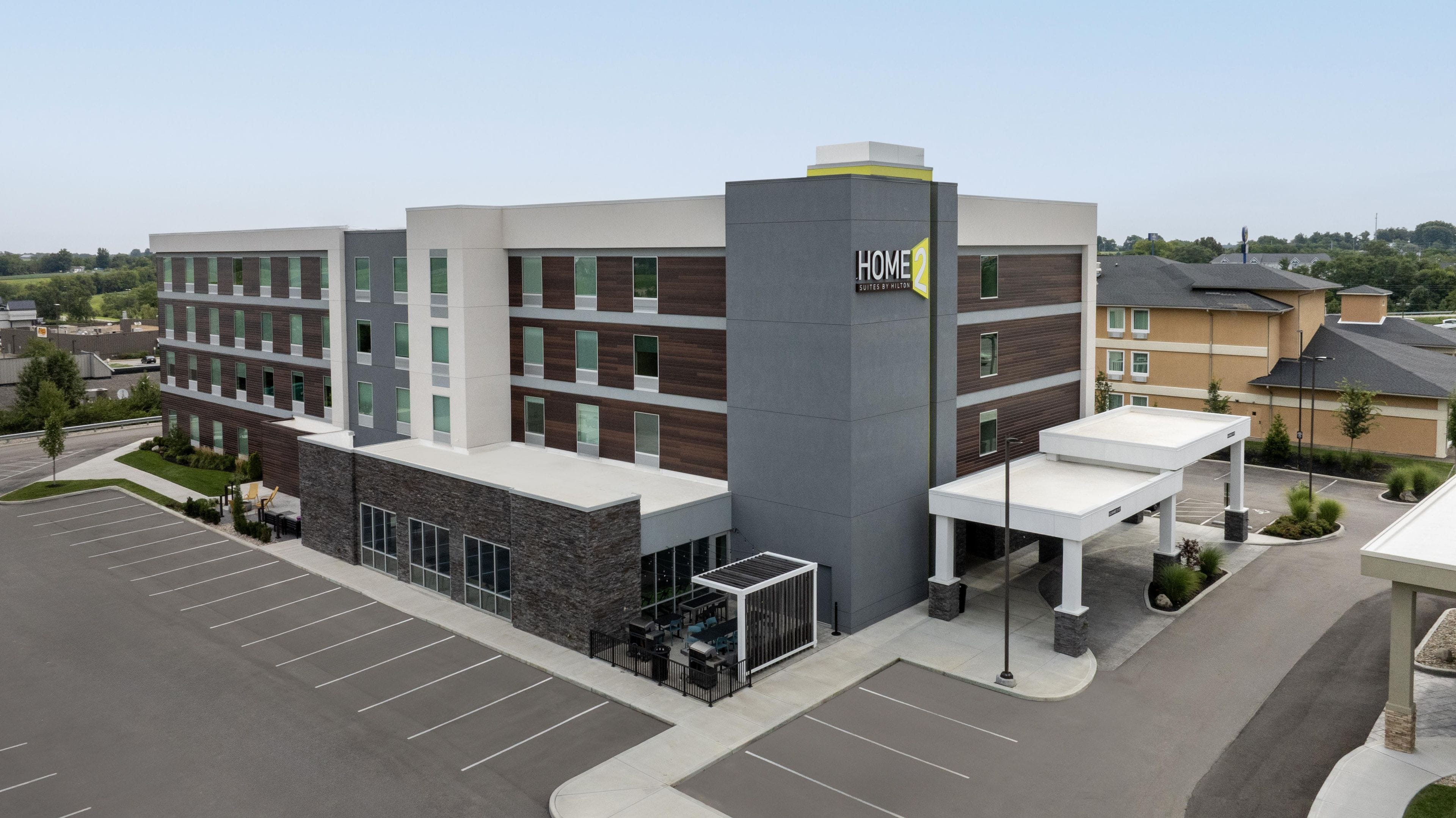 A multi-story hotel with a modern design, featuring a prominent 'HOME 2' sign on the facade.
