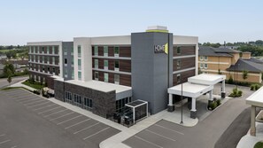 A multi-story hotel with a modern design, featuring a prominent 'HOME 2' sign on the facade.