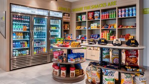 Ein Bereich mit Snacks und Getränken, darunter gekühlte Getränke, Müsliriegel und eine Auswahl an markierten Kappen.