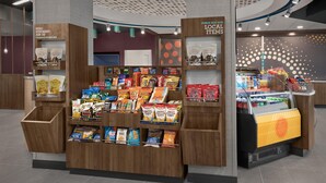 A snack display with various packaged foods and a sign indicating a 24/7 market. - Tru By Hilton Huntsville Research Park Area (Huntsville)