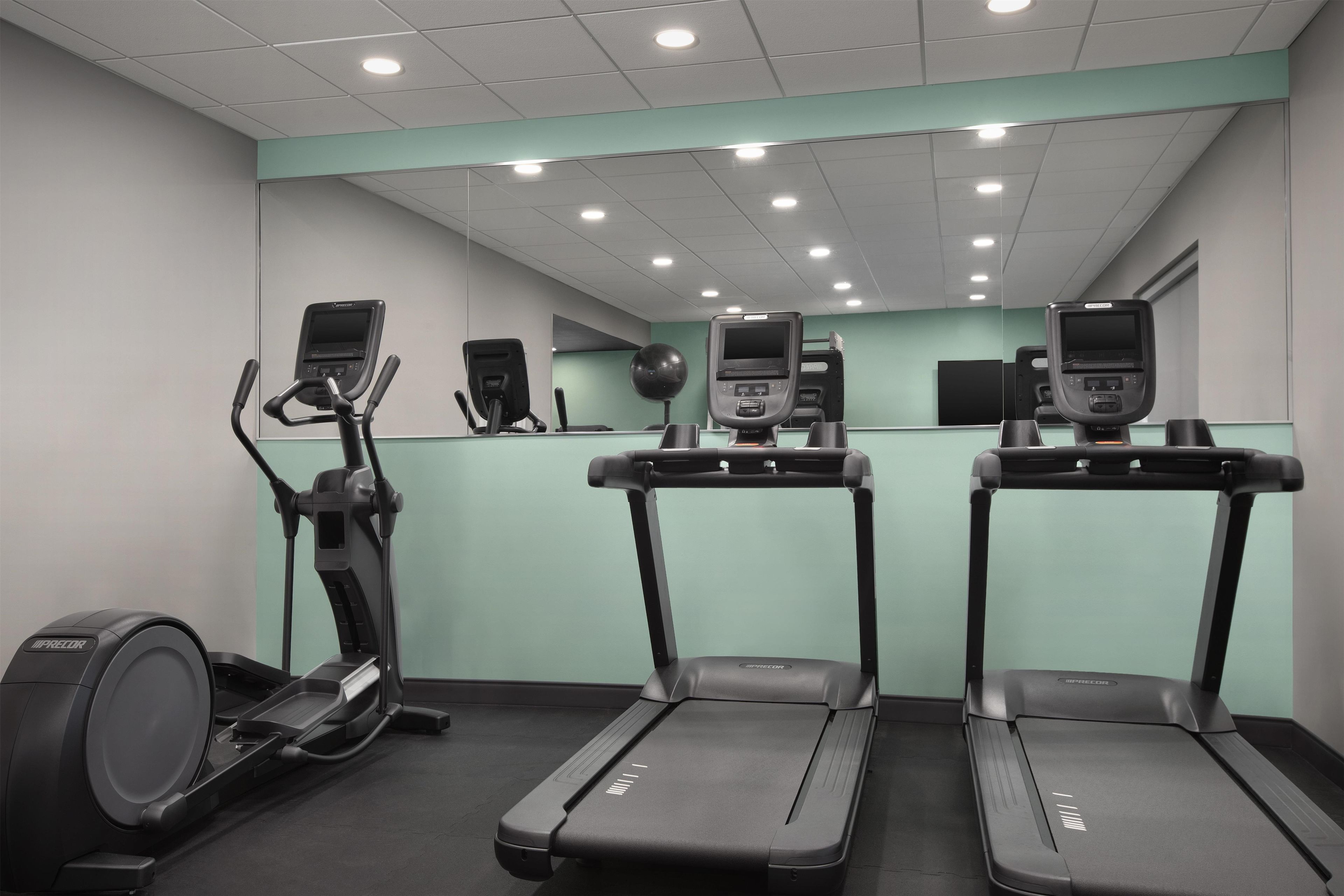 A gym with treadmills, an elliptical, and a stationary bike.
