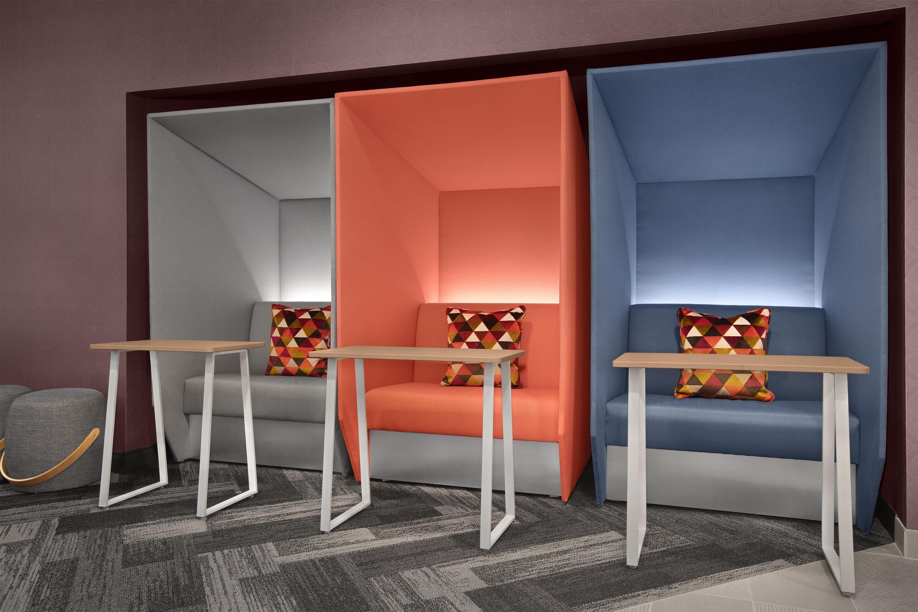 Una habitación moderna con tres zonas de estar, cada una con un diseño de cojines geométricos y colores únicos.